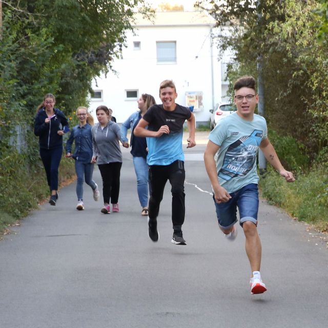 Rennende Schüler auf der Straße rennen auf die Kamera zu