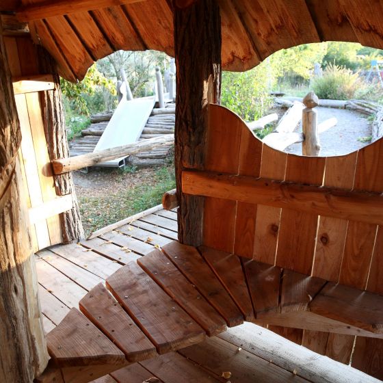 Ein Blick aus unserem Holzhaus mit wunderschönen ovalen Fensterformen des Hauses mit Blick auf den Rest des Schulgartens