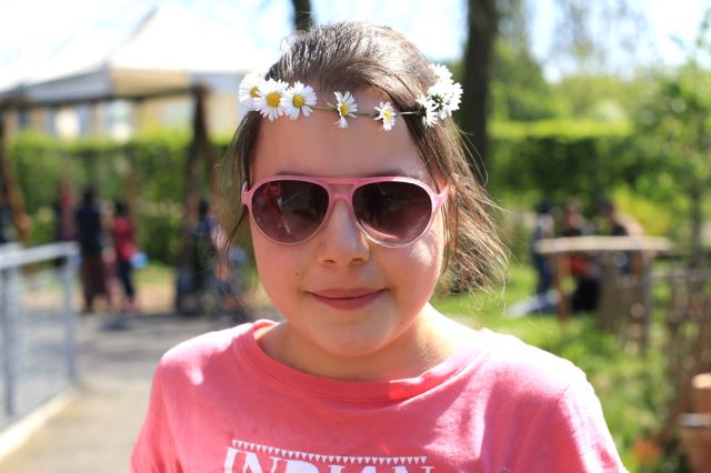 Mädchen mit Sonnenbrille und Blumenkranz beim Sommerfest