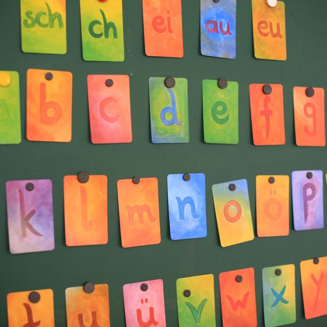 Kärtchen mit Alphabet hängen an der Tafel im Klassenzimmer