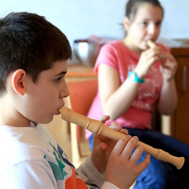 Zwei Schüler im Musikunterricht spielen Flöte